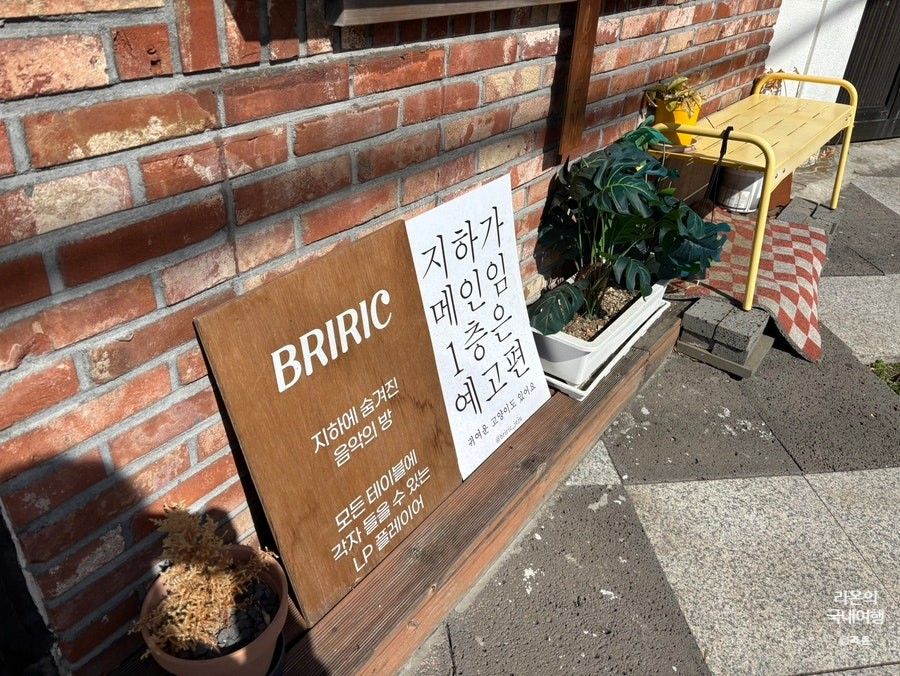 브리릭 입구 입간판 — '지하가 메인임 1층은 예고편'이라고 손글씨로 적힌 안내판