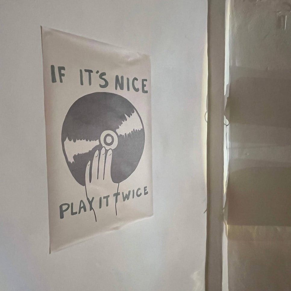 브리릭 벽에 붙은 포스터 — IF IT'S NICE PLAY IT TWICE, 손가락이 LP를 누르는 그림