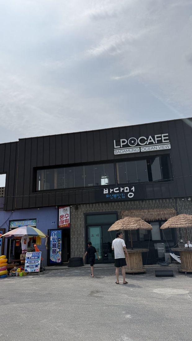 모래알 — LP CAFE 간판이 달린 검은 건물 외관, 협재해수욕장 앞 상가