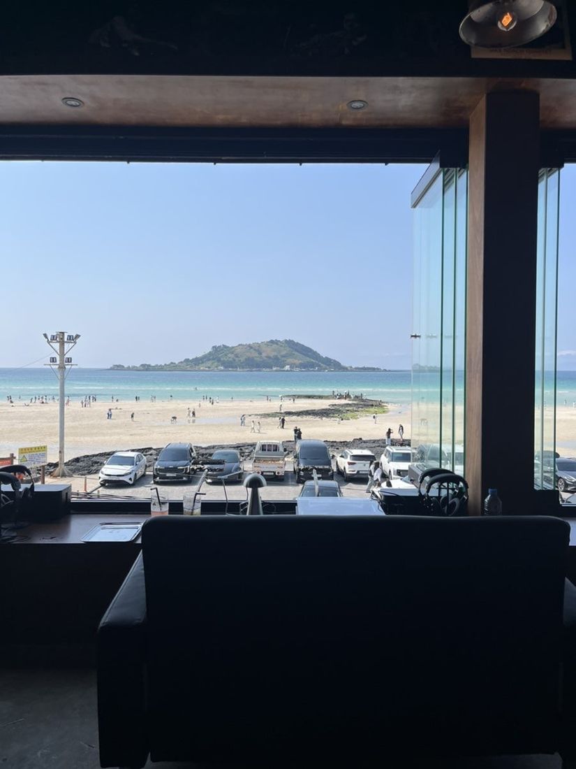 모래알 — 창가 소파 좌석에서 바라본 협재 바다와 비양도