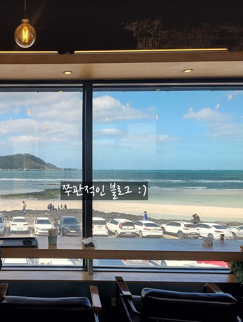 모래알 — 통창 너머로 보이는 협재해수욕장과 비양도