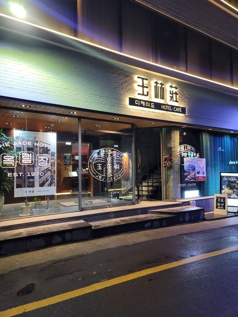 옥림사운즈 — 밤에 조명이 켜진 옥림장 EST.1970 간판이 붙은 건물 외관