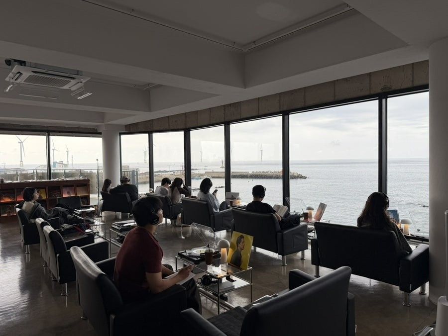 리버브제주 — 통창 전체가 바다인 홀. 창가석 뒤 일반석도 전부 창을 바라보게 배치했다