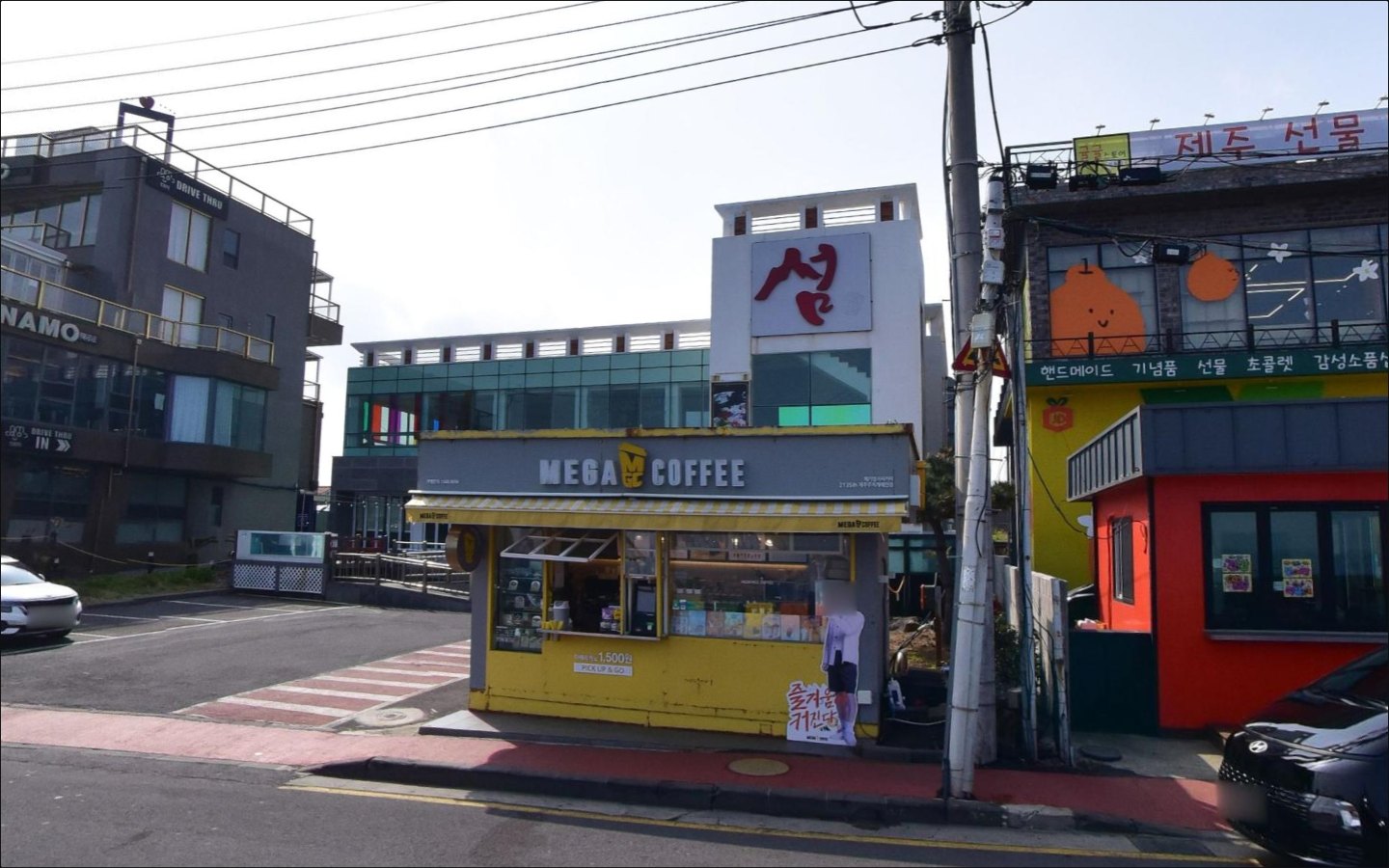 서해안로 242 건물 현재 로드뷰 — 2층 청록 유리 커튼월, 상단 흰 루버 띠, 오른쪽 「섬」 사인탑, 1층 전면 메가커피