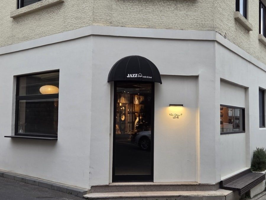 유콜잇러브 — 흰 코너 건물의 JAZZ cafe & bar 어닝 간판 외관